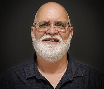 male owner headshot with white beard and hair wearing black shirt