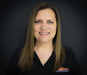 White female with brown hair wearing a black SERVPRO shirt and smiling