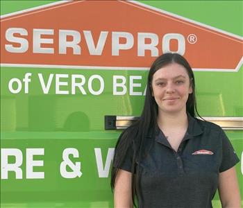 girl in grey shirt in front of green van