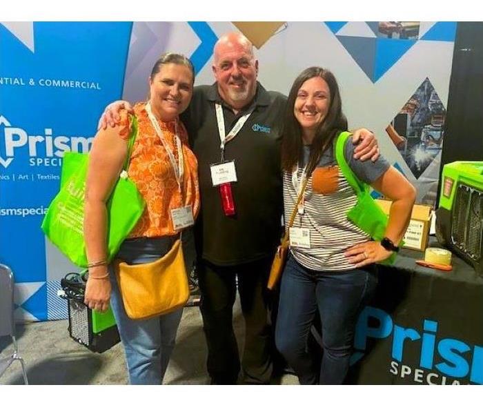 a man and two woman at trade show