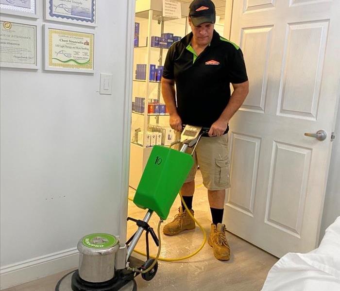 SERVPRO Production Technician cleaning a floor at a local salon.