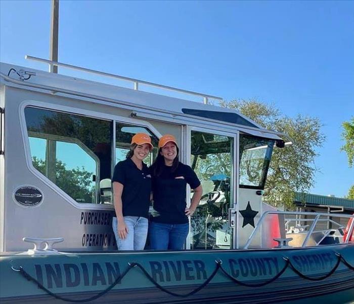 Two women standing on a sheriff's boat