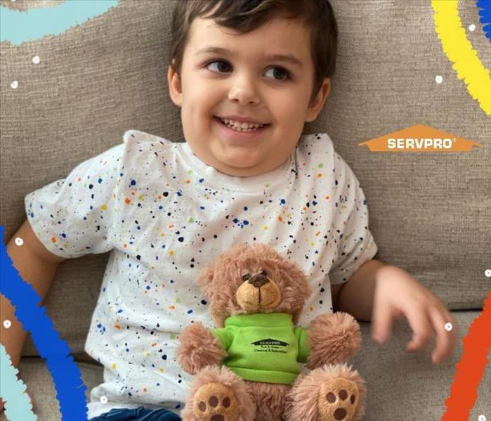 SERVPRO Teddy bear sitting on couch next to boy in multi colored shirt
