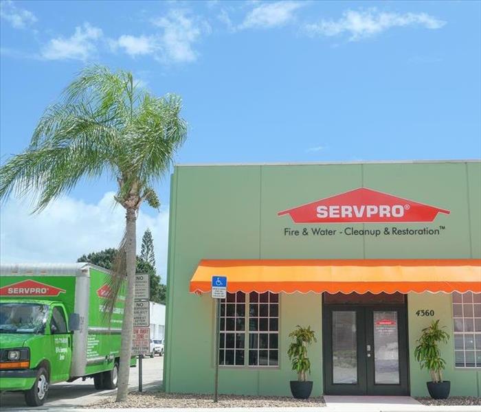 front of SERVPRO building on a sunny day, surrounded by SERVPRO truck and palm trees