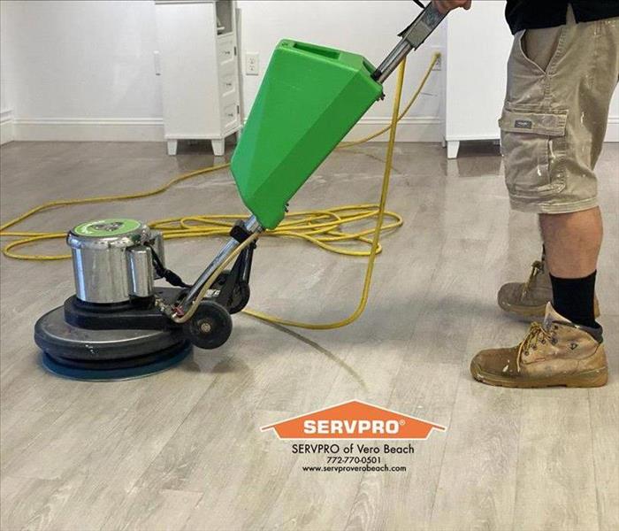 Man using a rotary cleaner to buff floors. 