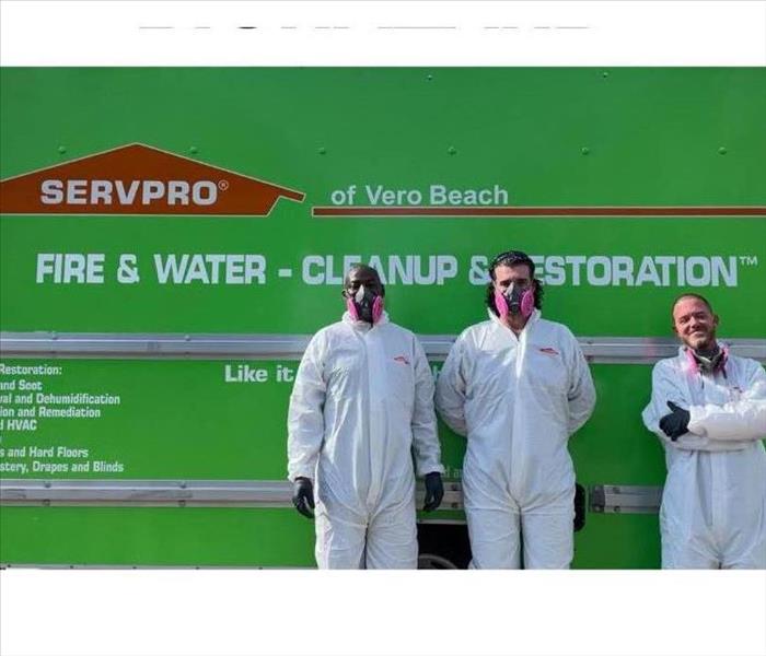 Three Men in PPE standing in front of a SERVPRO box truck